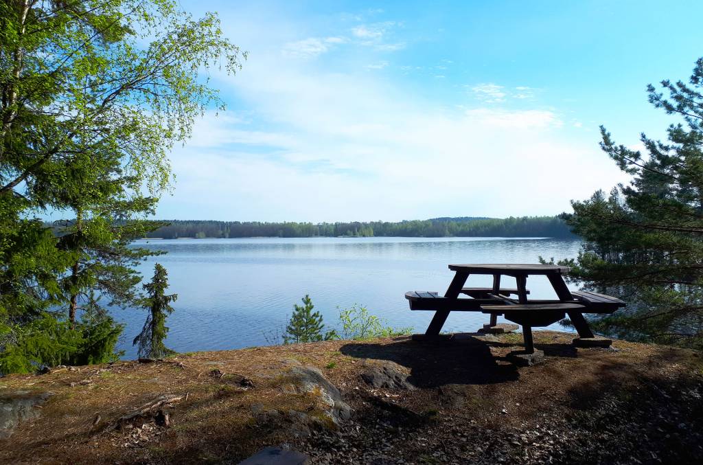 Levähdyspaikka Pappilanniemen luontopolulla kallionpäällä Vanajaveden rantamaisemassa.
