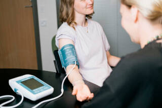 Sairaanhoitaja mittaa henkilön verenpainetta.
