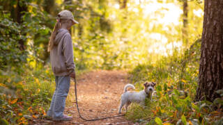 Tyttö ja koira Lotilan lenkillä metsässä.