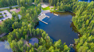 Kesäinen ilmakuva Kirjaslammen alueelta, jossa näkyy Kirjaslammen uimala ja metsää.