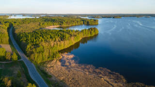 Ilmakuva Sääksmäeltä, jossa näkyy tie, metsää sekä järveä.